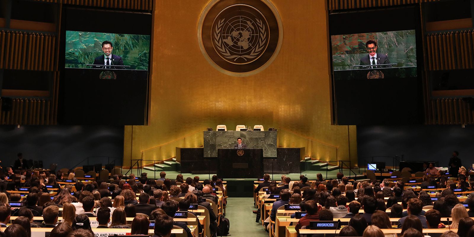 Ryan Villanueva delivering the keynote from the podium in the United Nations General Assembly Hall, addressing a full hall of delegates